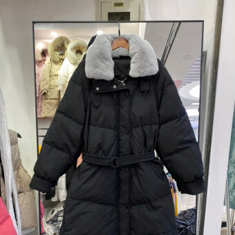 Zwart gewatteerd donsjack met grijze bontkraag en heupriem.