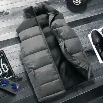 Grijs en zwart gewatteerd mouwloos donsjack met halfopen zakken met rits op donkergrijze strokenvloer. Aan de zijkanten zitten een zwarte pet, een zwarte trainer en een beetje een nummerplaat.