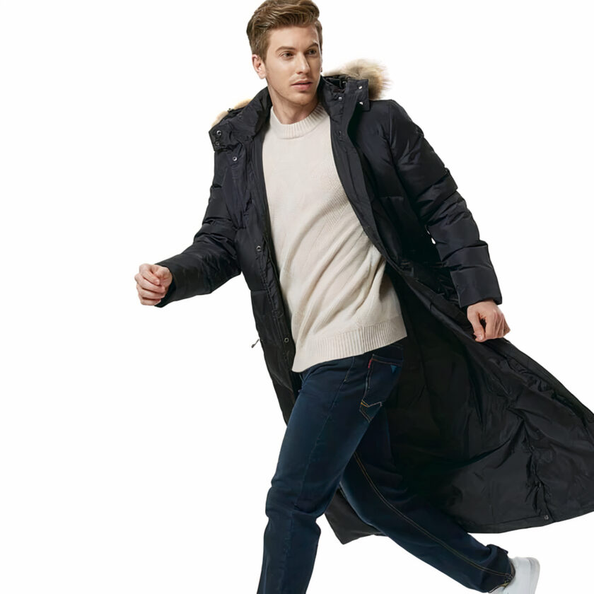 Donkerharige man loopt naar links en draagt een lange open zwarte donsjas met een witte trui eronder