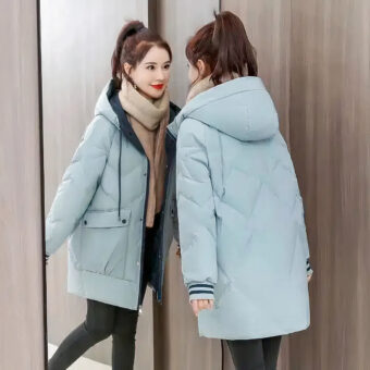 Vrouw met een blauw donsjack bekijkt zichzelf in een spiegel.