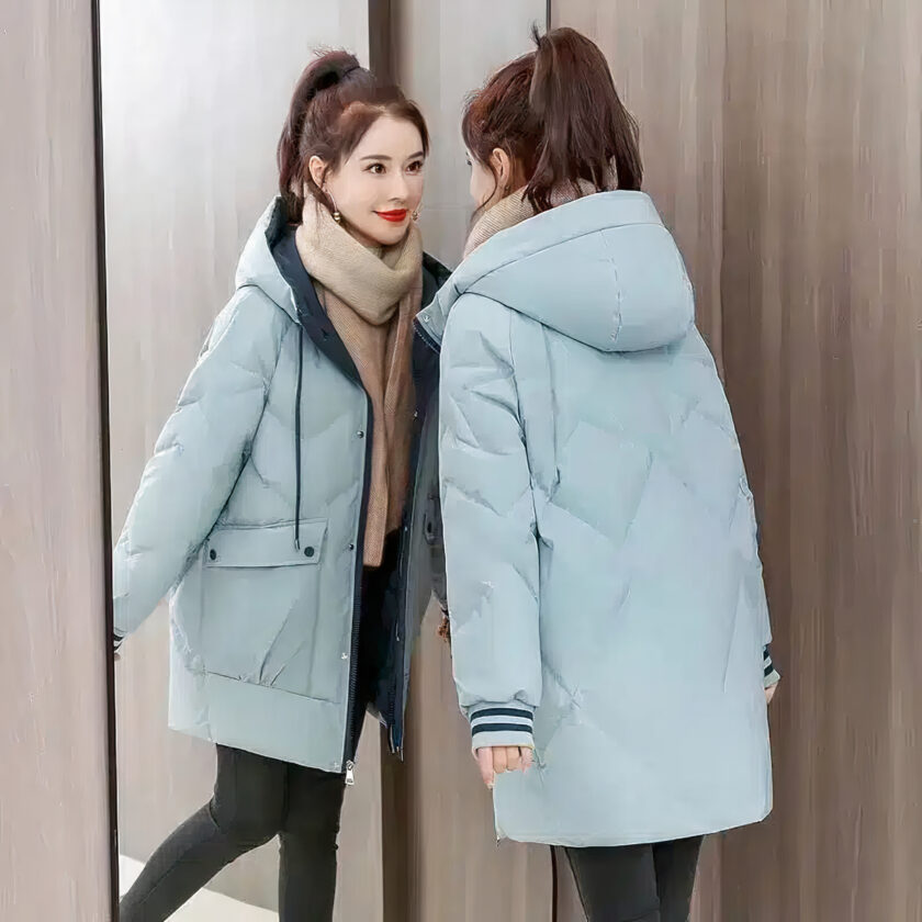 Vrouw met een blauw donsjack bekijkt zichzelf in een spiegel.