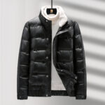 Zwart gewatteerd donsjack met fleece kraag; grijze achtergrond met schaduw.