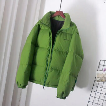 Groen donsjack aan een riem met een grijs gordijn erachter