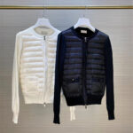 2 lichte zwart-witte donsjassen aan een kapstok opgehangen aan kleerhangers