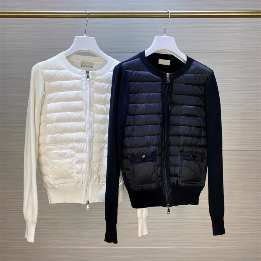 2 lichte zwart-witte donsjassen aan een kapstok opgehangen aan kleerhangers