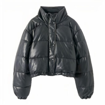We zien een zwart donsjack van imitatieleer op een witte achtergrond. De snit is heel modern, kort, crop-top. Het donsjack is gewatteerd.