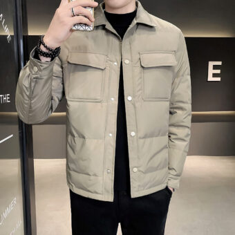 Man neemt een foto van zichzelf terwijl hij een licht donsjack met grote zakken draagt.