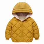We zien een eenvoudige, vrij lichte, gewatteerde donsjas met een capuchon. Het kledingstuk is mosterdgeel. De manchetten zijn nauwsluitend. De achtergrond van de afbeelding is wit.