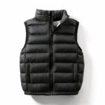 Een zwart, mouwloos, gewatteerd donsjack is afgebeeld tegen een witte achtergrond.