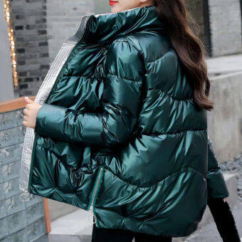 Donkerharige vrouw met een groen donsjack in profiel