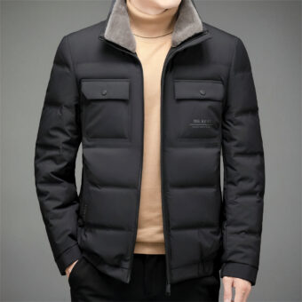 Kort, mat zwart jack met fleece kraag en twee zakken met drukknopen op de borst, halfopen gedragen door een man met een beige trui eronder.