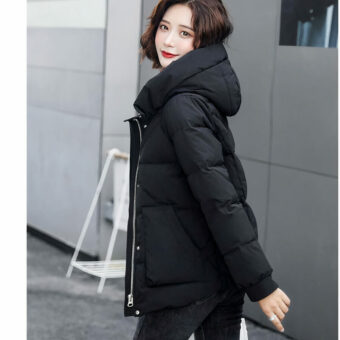 Foto van een vrouw met een kort zwart donsjack op straat