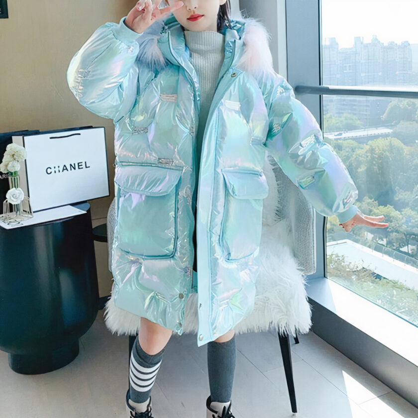 Blauwe winterdonsjas gedragen door een tiener in een flat voor een raam.