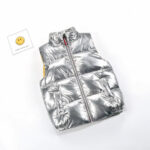 Foto van een zilver mouwloos donsjack van een kind met een smiley ernaast.