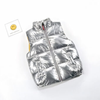 Foto van een zilver mouwloos donsjack van een kind met een smiley ernaast.