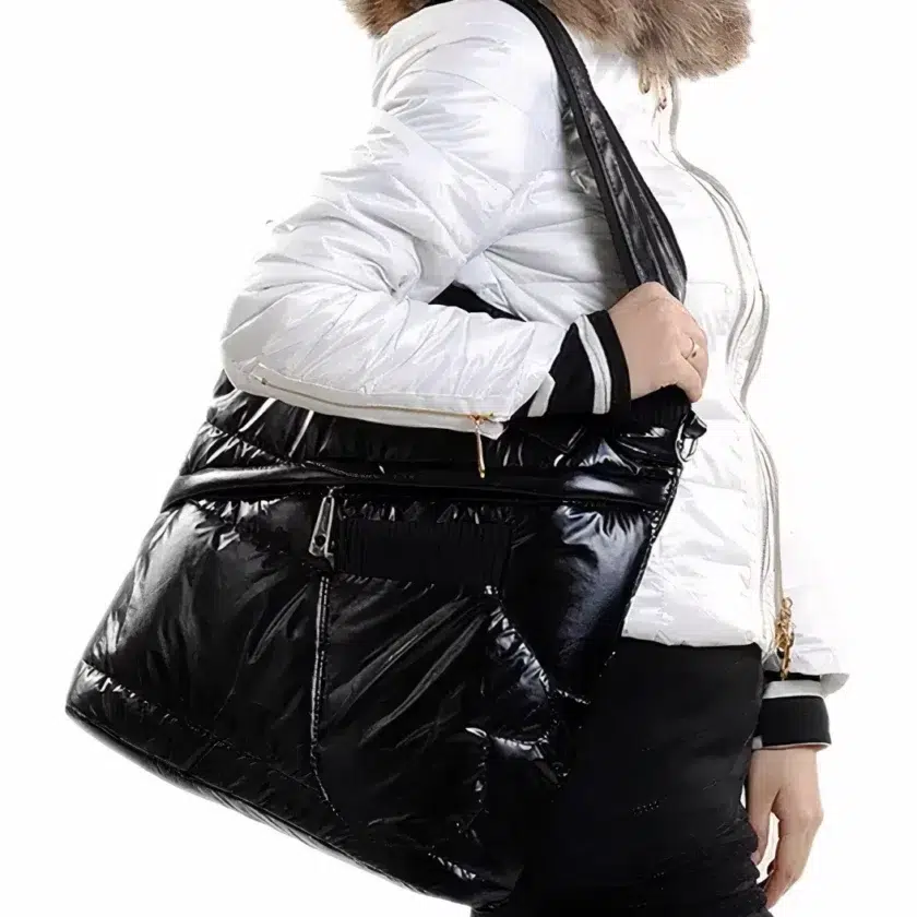 Zwart lak doudoune handtas Gezichtsloze vrouw aan de zijkant draagt een witte donsjas met bruin bont en draagt een rechthoekige zwarte tas van lakdons over haar schouder.