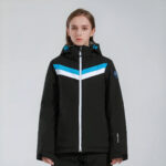 Vrouw draagt een zwart donsjack met blauwe en witte lijnen en een witte ritssluiting