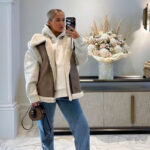 Vrouw draagt een mouwloos donsjack met bruin imitatiebont aan de binnenkant.