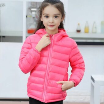 Klein meisje draagt een dun donsjack met capuchon voor kinderen in een kamer die eruitziet als een keuken.