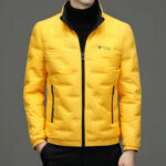 Borstbeeld van een man met een geel donsjack en een zwarte coltrui