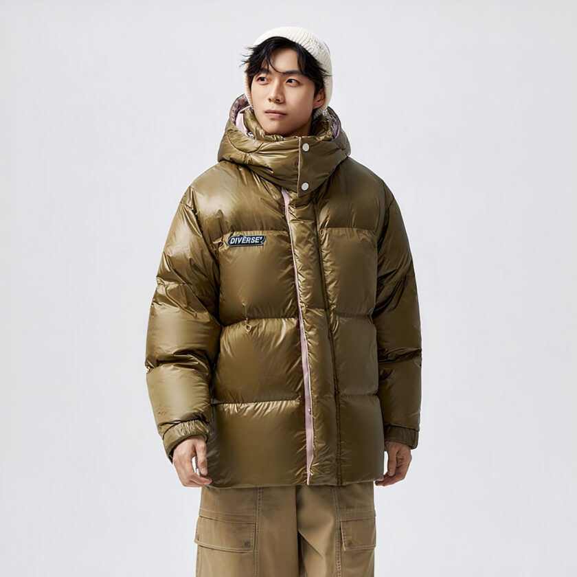 Foto van een man met een glanzende donsjas tegen een grijze achtergrond