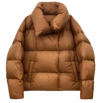 Gewatteerd donsjack voor dames met opstaande kraag en twee zijzakken. Camelkleurig op witte achtergrond.