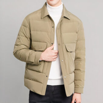 Foto van een man met een kort kaki donsjack tegen een grijze achtergrond