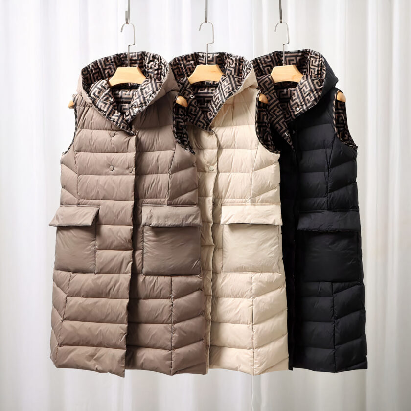 Bruine, witte en zwarte lange dunne mouwloze donsjacks op een rek.