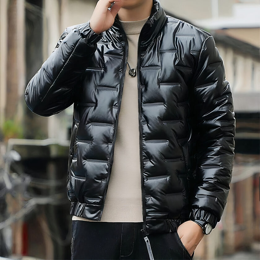 Foto van een man in een licht, kort zwart donsjack die over straat loopt en telefoneert