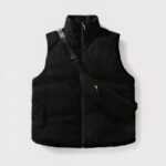 Dit is een mooi zwart mouwloos donsjack op een grijze achtergrond, in ribfluweel.