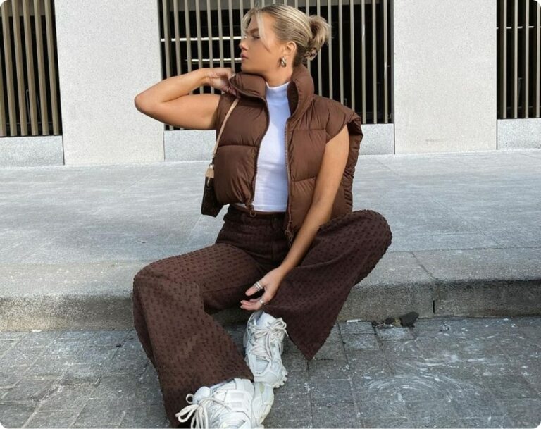 Vrouw in bruine jas zittend op stoep