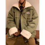 Man van gemengd ras zittend met een kaki donsjack met wit bont