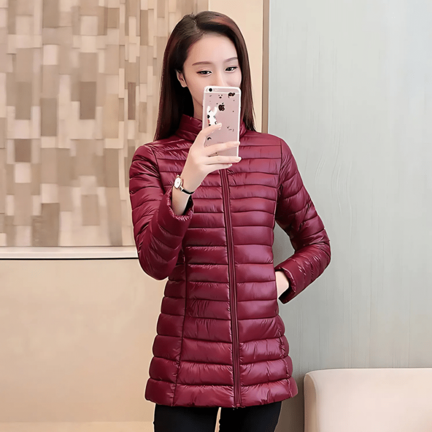 Dunne bordeauxrode halflange jas met hoge kraag gedragen door een jonge vrouw.