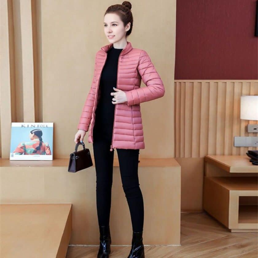 Dunne, halflange roze jas met een hoge kraag, gedragen door een jonge vrouw van wie het gezicht niet zichtbaar is