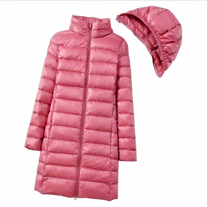 Lange roze gewatteerde damesjas met afneembare capuchon, plat neergelegd op een witte achtergrond met de capuchon afgehaakt