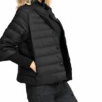 Een blonde vrouw draaide zich naar rechts en droeg een zwart vrouwenjack met korte mouwen,