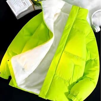 Open neon gewatteerd warm donsjack voor heren, met een voering van wit synthetisch bont tegen een zwart vlak met een witte helm ernaast.