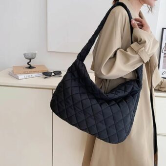 we zien een vrouw in een beige jas met een handtas van een donsjack voor vrouwen het is zwart